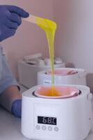 Waxing process in a beauty salon with warm wax and an applicator in use during daylight photo