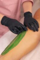 Waxing treatment on a clients leg at a beauty salon during a sunny afternoon session photo