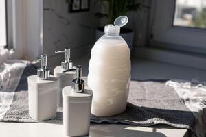 Various gray cosmetic containers arranged on a bright countertop in natural light photo