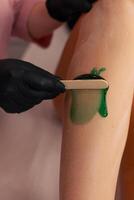 Waxing treatment on a clients leg at a beauty salon during a sunny afternoon session photo
