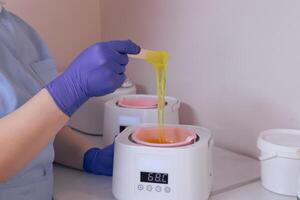 Waxing process in a beauty salon with warm wax and an applicator in use during daylight photo