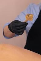 Waxing treatment being applied on a clients leg in a beauty salon during daylight hours photo