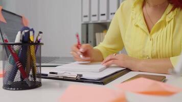 Woman hand taking notes of her new ideas working remotely. video