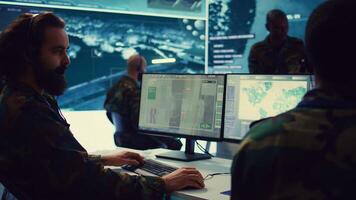 Reconnaissance department operator gathering information crucial for a national safety mission, transmitting intelligence to the troops. Telecommunications personnel in command post. Camera B. photo