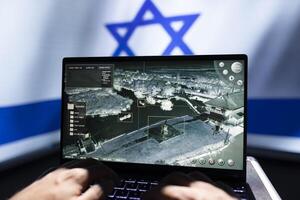 Israeli military personnel working on laptop, analyzing aerial reconnaissance data to come up with warfare winning tactics. Army specialist controlling drone, attacking strategic targets photo
