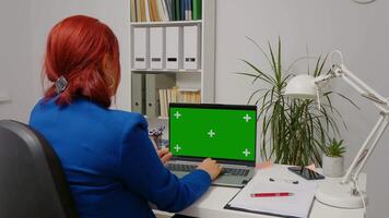 Business woman working in office interior on green screen laptop. video