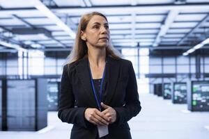 IT specialist walking in data center with advanced technology, ensuring cybersecurity and efficient network management. Engineer in server hub maintaining and optimizing data center infrastructure photo