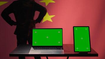China army soldier using isolated screen laptop and tablet to identify threats from enemies. Army personnel using software on chroma key devices to relay info to war front lines, camera B photo