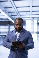 Data center technician ensuring safety and security of database using tablet. Server hub employee preventing unauthorized access and suspicious activities within the network posing risks for business photo