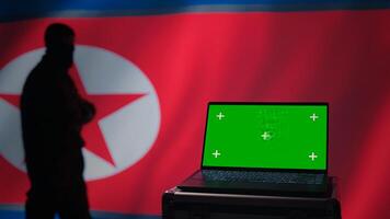 North Korea army soldier using military tech on green screen laptop to identify threats. Totalitarian regime agent using mockup notebook to relay info to front lines during korean conflict, camera B photo