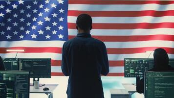 Cyber defense experts in a governmental tech room with the American flag. Working on secure computing, digital forensics and cyber operations to protect and maintain cyber safety. Camera B. photo
