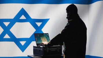 Communication systems operator working for Mossad using radio and satellite equipment, providing combat support. Israeli military dispatcher managing broadcasting networks, Israel flag, camera A photo