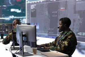 Military intelligence expert in a modern control room handles surveillance operations, analyzing real time satellite data and transmitting security measures to protect national interests. photo