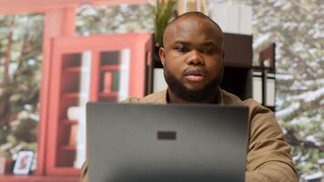 Accountancy specialist examining business funds and profit from annual sales, studying market statistics data on a laptop at home. Business owner creating a new investment plan. Camera A. photo