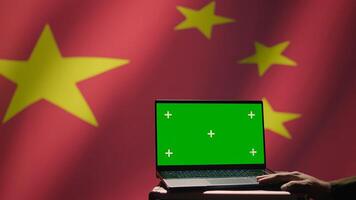 Chinese soldier using military tech on green screen laptop to identify threats from enemies. Army personnel using software on mockup notebook to communicate information to war front lines, camera B photo
