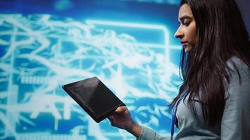 Programmer using tablet to maintenance artificial intelligence neural networks. Close up shot of computer scientist using AI system aiding in processing and transmitting information, camera B photo