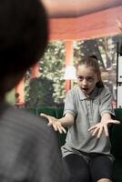 Troubled teen displays aggression and anger during therapy session, rebellious adolescent throwing a tantrum. Expert focuses on resolving issues like anger management issues and negative behavior. photo