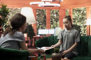 Teenage girl presents disturbing artwork during a therapy session. The sketches reflect dark, violent emotions and warning signs of deeper psychological struggles, including trauma and isolation. photo
