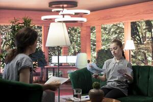 Teenager showing dark gory sketches that reveal anxiety and warning signs, violent thoughts during a therapy session. Psychologist analyzes disturbing art, searching for signs of hostility. photo
