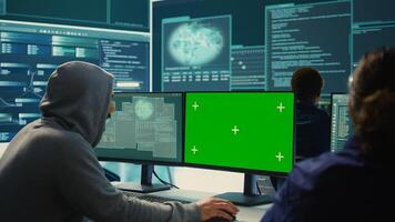 Governmental hackers working on computer with green screen to protect data and network security. Focusing on cyber defense, malware detection to prevent cyber attacks and espionage. Camera B. photo