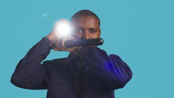 Headshot portrait of security staff member evicting trespassers with baton after spotting them with flashlight. Close up of patrolling agent using truncheon and lantern to evict intruders, camera B photo