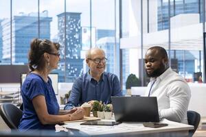 Senior couple consulting with a professional financial advisor in a modern office to discuss comprehensive retirement plans. Planning investments with life savings and pension options. photo