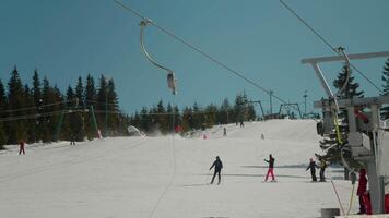 People skiing and snowboarding downhill a view from afar. video