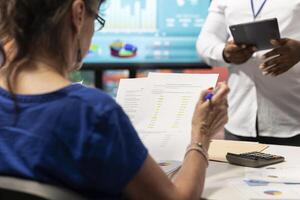 Senior woman studying potential contract terms in a meeting with financial expert, counseling for a secure retirement plan. Advisor working to cover savings and family expenses. photo