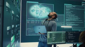 Cyber defense expert examining data on a big screen in governmental agency, focusing on cyber operations and digital security. Hacker ensures protection against cybercriminal activities. Camera B. photo
