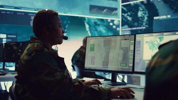 Female army operator registers important information from military surveillance system, working in control room base of operations to gather intelligence for the troops. National safety. Camera B. photo