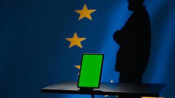 European Union counterintelligence division uses green screen tablet to protect against propaganda affecting elections. EU security service safeguarding democracy online using mockup device, camera A photo