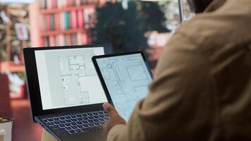 Entrepreneur planning an office relocation evaluating architectural blueprints, consulting with interior designers to create an inspiring workspace. Hunting for property leasing. Camera A. photo