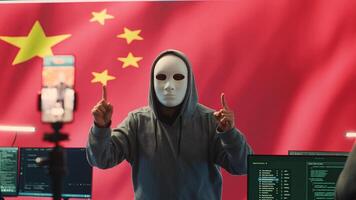 Anonymous hacker expert in a Chinese hacking high tech office, digital threats and political espionage. Inflicting cyber terror, propaganda and crisis management in information war. Camera A. photo