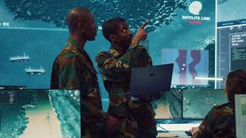Signal support systems specialists work with battlefield data and terminal devices in military command post. Reconnaissance operators targeting enemy warships on CCTV radar. Camera A. photo