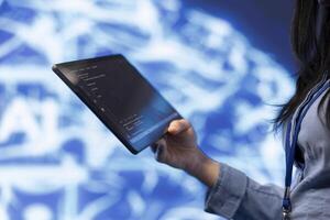 Software developer with tablet programming artificial intelligence computing simulating human brain. Close up of IT professional using device, building AI machine learning algorithms photo