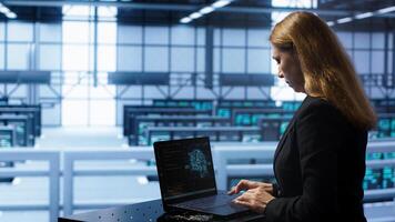 Engineer in data center using artificial intelligence computing simulating human brain thought processes in computerized model. Employee works on laptop with AI machine learning algorithms, camera A photo