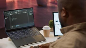 AI software developer creating an algorithm for deep learning and data mining, coding on his laptop at home office. Expert processing binary code on supercomputer neural network. Camera A. photo
