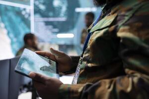 High tech military office with soldiers analyzing real time data, processing intelligence information and coordinating strategic operations to support military missions effectively. photo