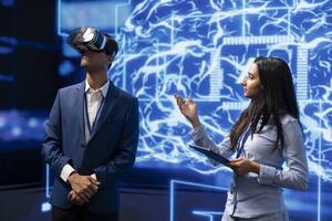 Technology company CEO using conference as platform to present latest AI and VR headsets products. IT experts at convention showing business investors virtual reality tech photo