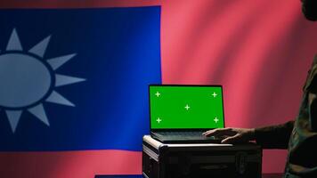 Taiwanese insurgent using military tech on green screen laptop to identify threats from enemies. Taiwan freedom fighter using software on mockup notebook to relay info to war front lines, camera B photo
