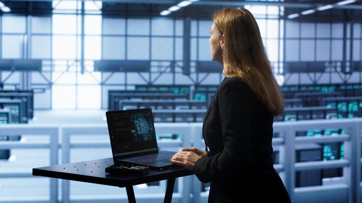 Admin in data center works with artificial intelligence computerized model simulating human brain. Employee working on notebook with AI machine learning algorithms using pattern recognition, camera A