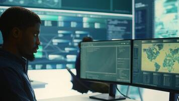 Governmental hackers analyzing data for cyber threat detection, looking at a big screen in high tech office. Highlight cyber intelligence, online security and prevention of digital threats. Camera B. photo