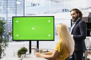 Financial adviser conducting audit of clients income, doing presentation on green screen to help them build saving habits. Agent using large mockup display to show investing tips photo
