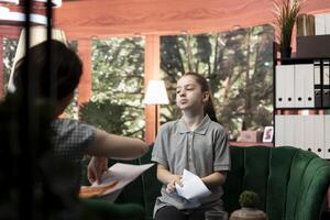 Adolescent showing rudeness and mood swings with therapist after revealing her gory unsettling sketches, worried psychologist at counseling, Warning signs and negative behavior. photo