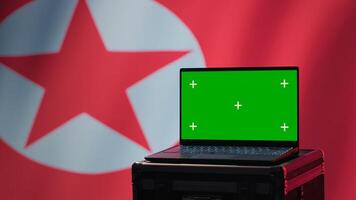 Isolated screen laptop in Pyongyang intelligence command center used by dictatorship party to run security protocols against NATO and South Korea enemies, isolated over North Korea flag, camera A photo