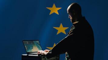 European Union alliance soldier in control room uses military tech to identify threats. EU intelligence agency operator uses software to relay info to front lines, protecting member states, camera A photo