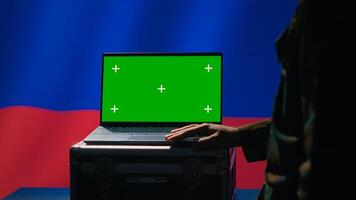 Russian soldier using military tech on green screen laptop to identify threats from enemies. Russia ex KGB FSB personnel using software on mockup notebook to relay info to war front lines, camera A photo