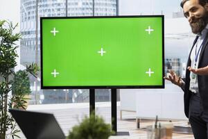 Financial adviser presents market analytics on green screen display to clients, teaching them how to build portfolio. Broker showing stock exchange charts on mockup device to family photo