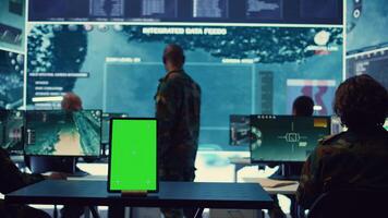 Isolated greenscreen display running on a tablet in military power base, soldiers follow surveillance footage to stay alert in case of a hostile attack. Satellite system for reconnaissance. Camera B. photo