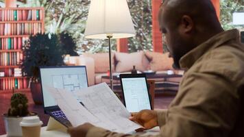 Professional entrepreneur examining blueprints and using digital tools for office space planning and development. Business owner workspace design for renting, investment strategy. Camera B. photo